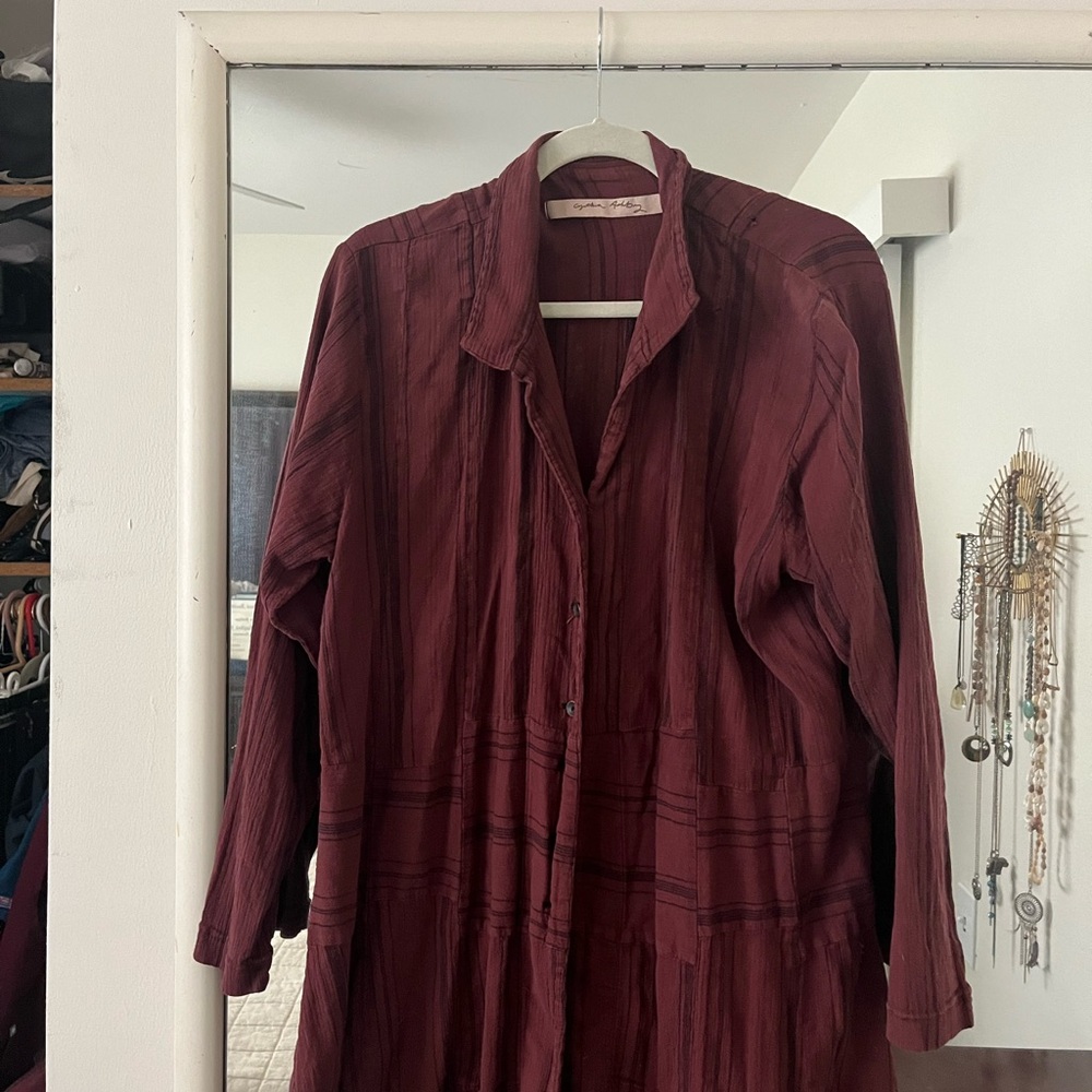 Long sleeve button down blouse. Uneven cut at bottom.One small whole in shoulder